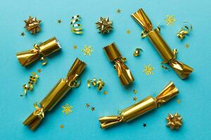 Christmas crackers with shiny confetti on color background, top view, copy space photo