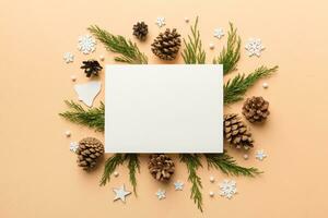 Flat lay Christmas composition. square Paper blank, pine tree branches, christmas decorations on Colored background. Top view, copy space for text photo