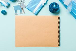 Top view of notebook on blue background made of Christmas decorations. New Year time concept photo