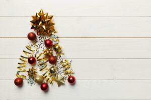 Christmas tree made from colored ball decoration on colored background, view from above. New Year minimal concept with copy space photo
