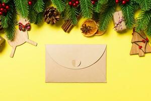 Top view of envelope on yellow background. New Year decorations. Christmas holiday concept photo