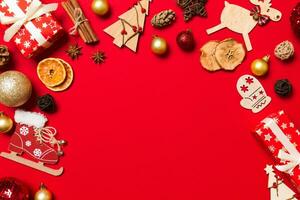 vista superior de adornos navideños sobre fondo rojo. concepto de vacaciones de año nuevo con espacio de copia foto