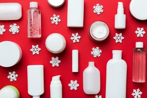 Makeup products and Christmas decorations on color background. Top view New year Beauty concept photo