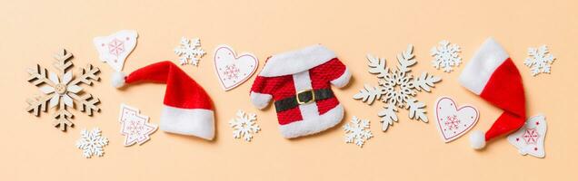 Top view Banner of Christmas decorations and Santa hats on orange background. Happy holiday concept with copy space photo