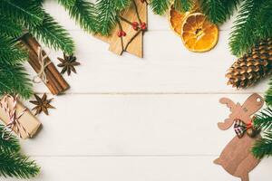 Top view of fir tree branches and festive decorative toys on wooden background. New Year time concept with empty space for your design photo