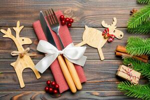 Top view of utensils on festive napkin on wooden background. Christmas decorations with dried fruits and cinnamon. Close up of New year dinner concept photo