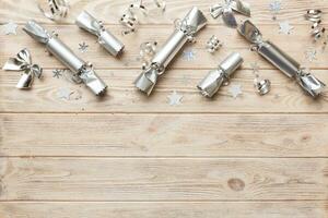 Christmas crackers with shiny confetti on color background, top view, copy space photo