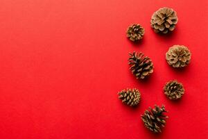 Christmas pine cones on colored paper border composition. Christmas, New Year, winter concept. Flat lay, top view, copy space photo