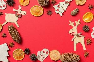 Top view of red background decorated with festive toys and Christmas symbols reindeers and New Year trees. Holiday concept with copy space photo