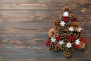 Christmas tree made from natural cones on colored background, view from above. New Year minimal concept with copy space photo