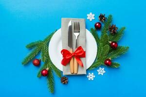 Christmas table place setting with christmas decor and plates, kine, fork and spoon. Christmas holiday background. Top view photo