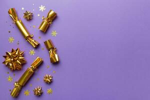 Christmas crackers with shiny confetti on color background, top view, copy space photo