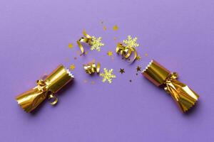 Christmas crackers with shiny confetti on color background, top view, copy space photo