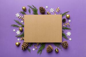 Flat lay Christmas composition. square Paper blank, pine tree branches, christmas decorations on Colored background. Top view, copy space for text photo