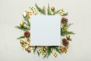 Flat lay Christmas composition. square Paper blank, pine tree branches, christmas decorations on Colored background. Top view, copy space for text photo