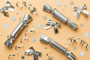 Christmas crackers with shiny confetti on color background, top view, copy space photo