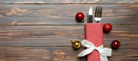 Top view Banner of holiday set of fork and knife on wooden background. Christmas decorations and toys with copy space. New Year Eve concept photo