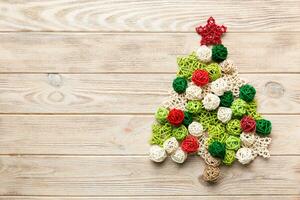 Christmas tree made from colored handmade ball decoration on colored background, view from above. New Year minimal concept with copy space photo
