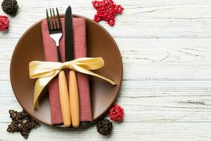 Holiday composition of Christmas dinner on wooden background. Top view of plate, utensil and festive decorations. New Year Advent concept with copy space photo