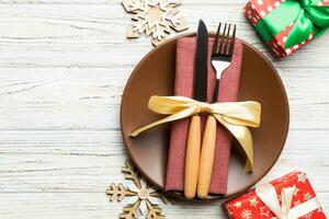 vista superior del plato, tenedor y cuchillo servido sobre fondo de madera decorado con navidad. concepto de víspera de año nuevo con espacio de copia foto