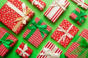 A lot of Christmas gift boxes in colored paper decorated on table, Top view close up. Many present New Year gift photo