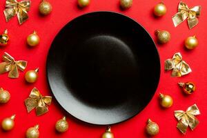 Top view of holiday dinner on colorful background. Plate, baubles and bows. Christmas Eve concept photo