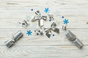 Christmas crackers with shiny confetti on color background, top view, copy space photo