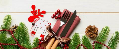 Top view Banner of flatware tied up with ribbon on napkin on wooden background. Christmas decorations and reindeer with empty space for your design. New Year holiday concept photo