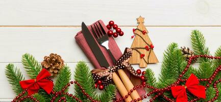 Banner top view of festive cutlery on new year wooden background. Christmas decorations with empty space for your design. Holiday dinner concept photo