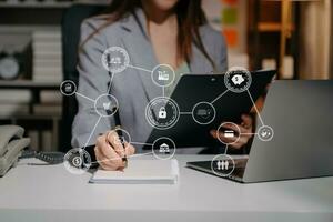 close up of businessman working with laptop computer and smart phone on desk in modern office with virtual icon diagram photo