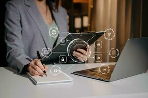 close up of businessman working with laptop computer and smart phone on desk in modern office with virtual icon diagram photo