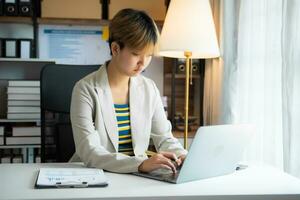 Young Woman Account Manager Working at Table with New Business Project. Typing keyboard,Using Contemporary Laptop. photo