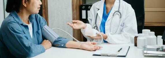 A professional physician talks to discuss results or symptoms and gives a recommendation to a male patient and signs a medical paper at an appointment visit in clinic. photo