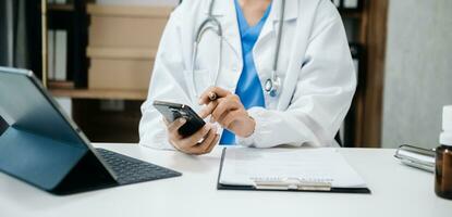 Medical technology concept. Doctor working with mobile phone and stethoscope and digital tablet laptop in office at hospital photo