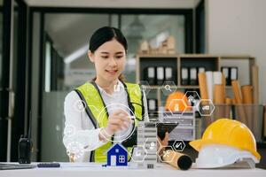business woman hand working and laptop with on on architectural project at construction site at desk in office photo