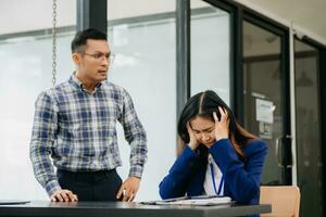 Furious two Asian businesspeople arguing strongly after making a mistake at work in office photo