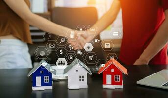 balancing the property sector The real estate agent is explaining the house style to see the house design and the purchase agreement.Wooden house at office photo