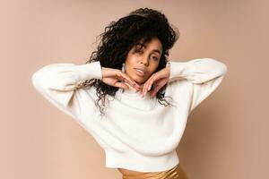 Sensual african american woman  looking at camera. Studio shot of beautiful black female model isolated on beige background. photo