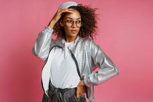 pretty mix race woman with  curly Afro hairs posing on pink background. photo