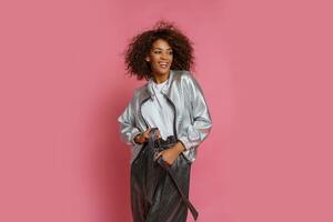 pretty mix race woman with  curly Afro hairs posing on pink background. photo