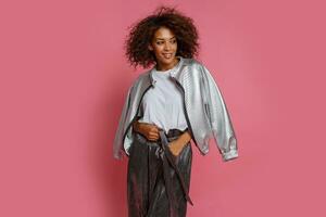pretty mix race woman with  curly Afro hairs posing on pink background. photo