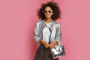 pretty mix race woman with  curly Afro hairs posing on pink background. photo
