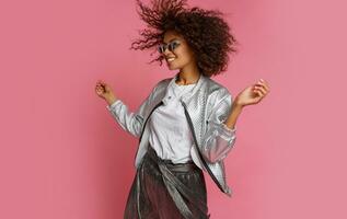 pretty mix race woman with  curly Afro hairs posing on pink background. photo