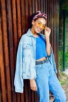 Happy  hipster mixed girl with perfect whit teeth spending great time outdoor . Trendy jeans jacket. photo