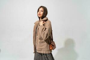 Studio  photo of fascinating woman in winter fur coat posing on white background.