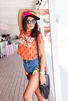 Outdoor   lifestyle  portrait of young amazing brunette woman , orange print t-shirt . photo