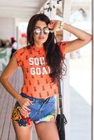 al aire libre estilo de vida retrato de joven increíble morena mujer , naranja impresión camiseta . foto