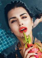Close up  beauty portrait of beautiful woman with slice of dragon fruit,  bright make up. photo