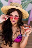 Pretty beach woman in  bright color  swimwear, pink heart sunglasses  and straw hat enjoying  summer . photo