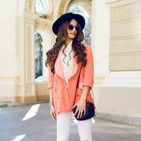 Outdoor fashion portrait of stylish casual woman  in black hat, pink suit ,  white blouse posing on old street background. Spring , fall sunny day. Wavy hairstyle. photo